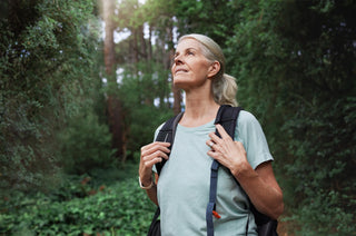Woman with a backpack standing in a forest