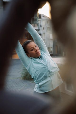 Woman stretching outdoors with a blurred background